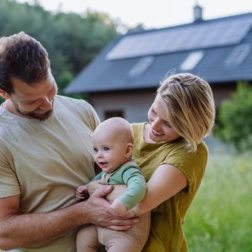 Happy,Family,Near,Their,House,With,Solar,Panels.,Alternative,Energy,